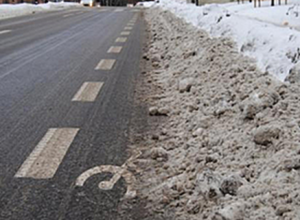 bilde av en snødekket sykkelvei langs en vei