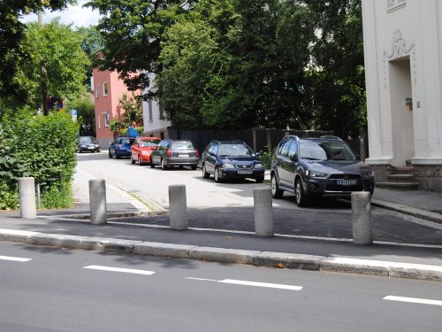 Bilde av området der to veier møtes, men som er adskilt av en opphøyning med kjøresperrer.