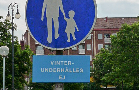 : foto av et veiskilt som viser at det er en gangvei, med et tilhørende underskilt som informerer om at gangveien ikke måkes eller strøs vinterstid.