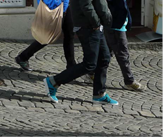 bena til mennesker som går på brostenbelegning.