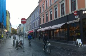 av syklister som sykler i sykkelgate i et bymiljø.