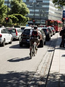syklist som sykler på en trafikkert gate.