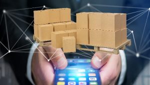 Grafikk av en mann som holder en telefon med svevende paller med papp bokser på som flyter over mobilen med logistikk streker rundt.