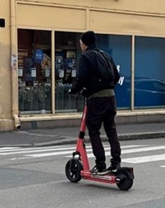toet viser en mann som står på en elektrisk sparkesykkel.