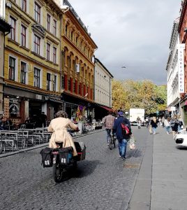 Bilde av personer som sylker og går i by miljø