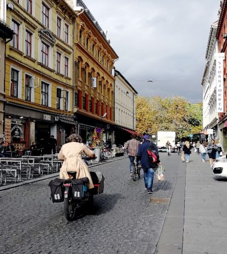Bilde av personer som sylker og går i by miljø