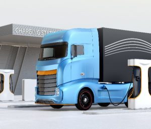 Grafikk som viser en elektrisk lastebil som lader ved en ladestasjon.