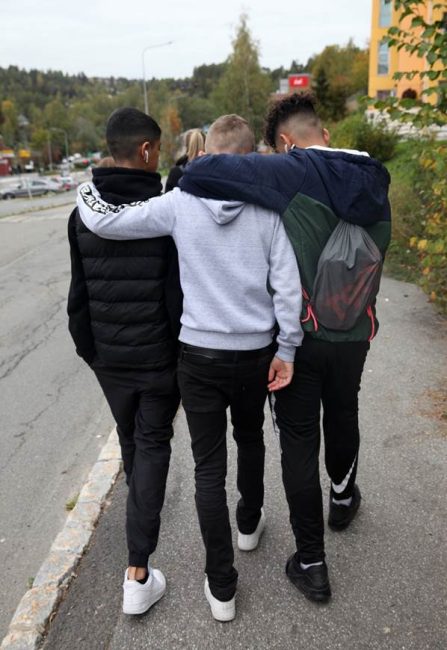 Foto av unge som g&aring;r langs vei.