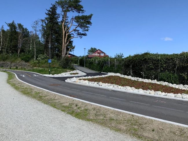 fotoet viser en ny-asfaltert sykkelvei, med en grusbelagt tursti p&aring; siden.